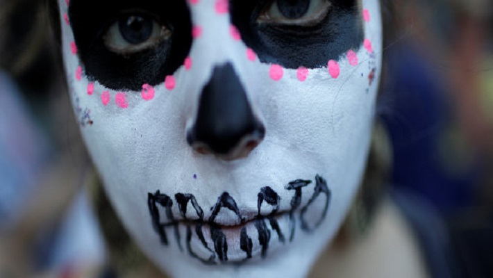 A woman demonstrates against Brazil’s congressional move to criminalize all cases of abortion, including cases of rape and where the mother’s life is in danger, with a face painting representing a woman dead after an illegal abortion, in Rio de Janeiro
